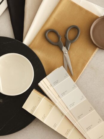 Interior design mood board materials, fabric samples, and ceramic dishes curated for a space alignment project.